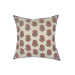 Throw pillow with printed and embroidered floral pattern in coral and purple on white.
