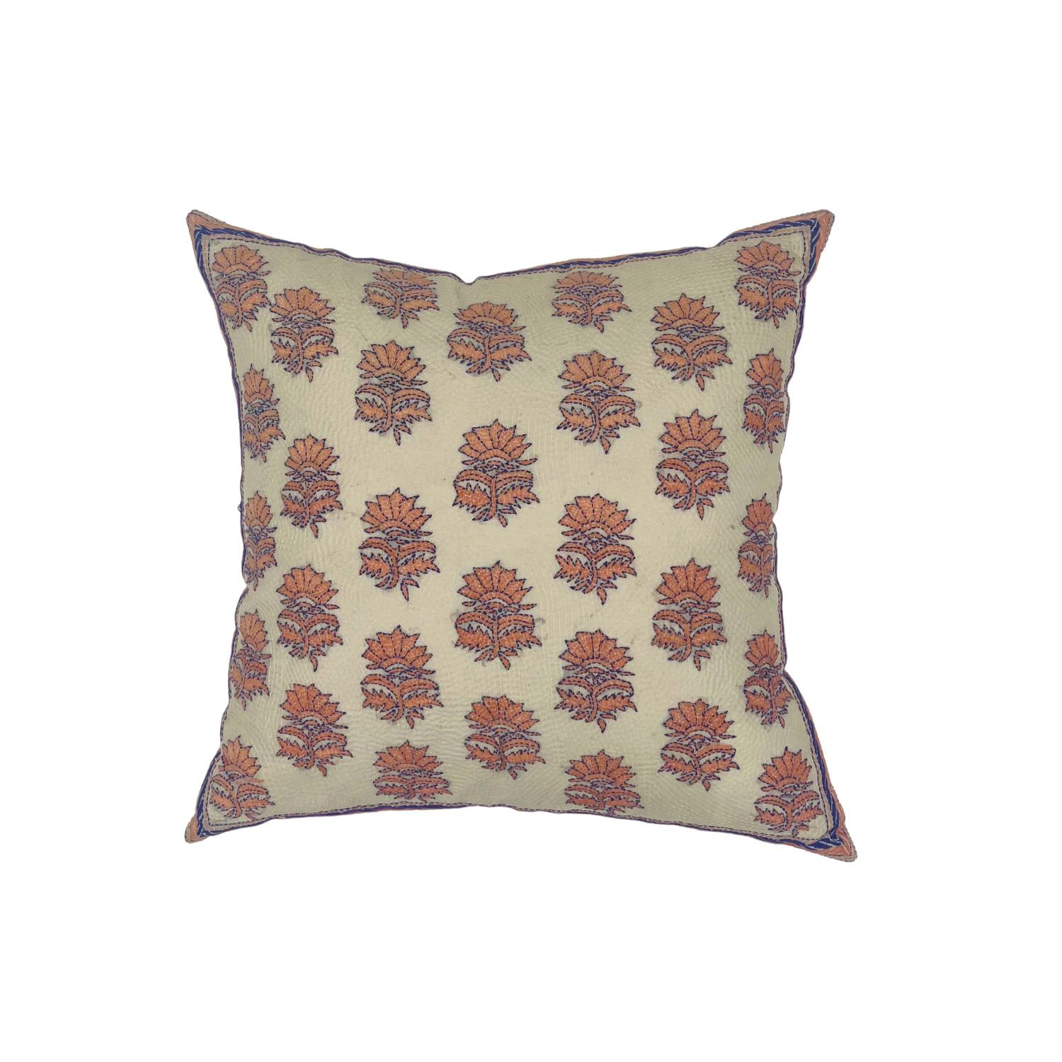 Throw pillow with printed and embroidered floral pattern in coral and purple on cream. 