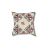 Throw pillow with printed and embroidered design in a floral medallion in pink orange and green. 