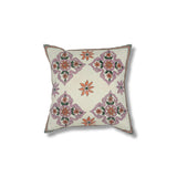 Throw pillow with printed and embroidered design in a floral medallion in pink orange and green. 