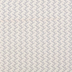 Panel of embroidered fabric in a linear geometric print in white and navy on a cream field.