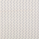 Panel of embroidered fabric in a linear geometric print in white and navy on a cream field.
