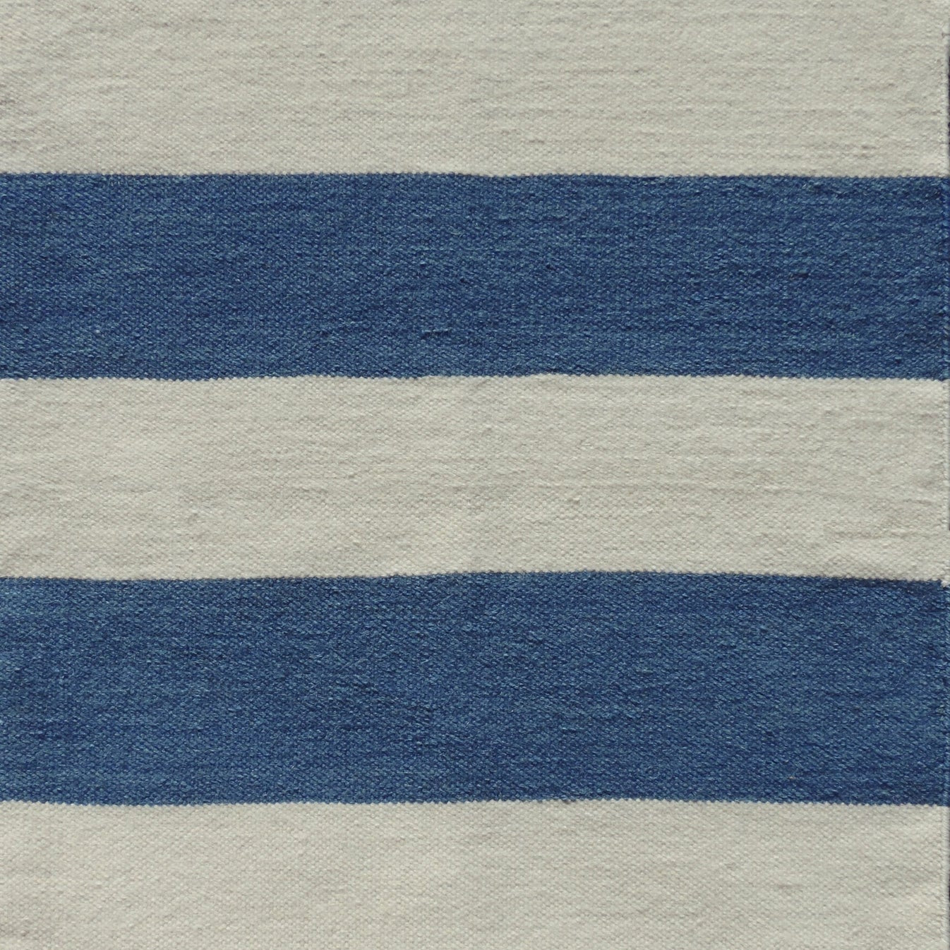 Handwoven rug with wide stripes in cream and royal blue. 
