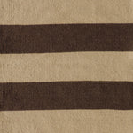 Handwoven rug with wide stripes in tan and dark brown. 