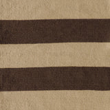 Handwoven rug with wide stripes in tan and dark brown. 