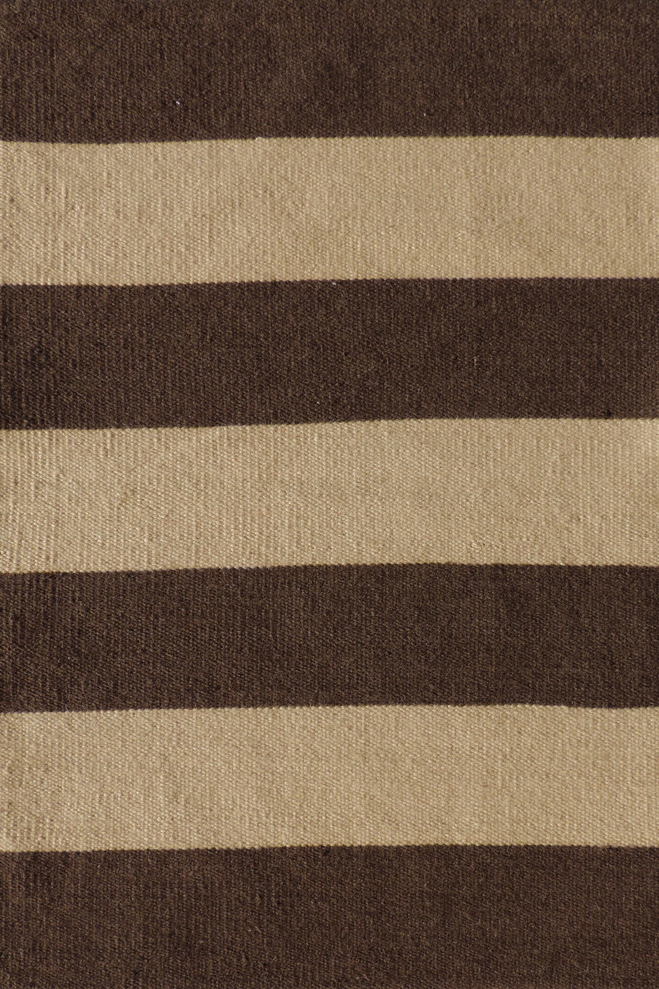 Handwoven rug with wide stripes in tan and dark brown. 