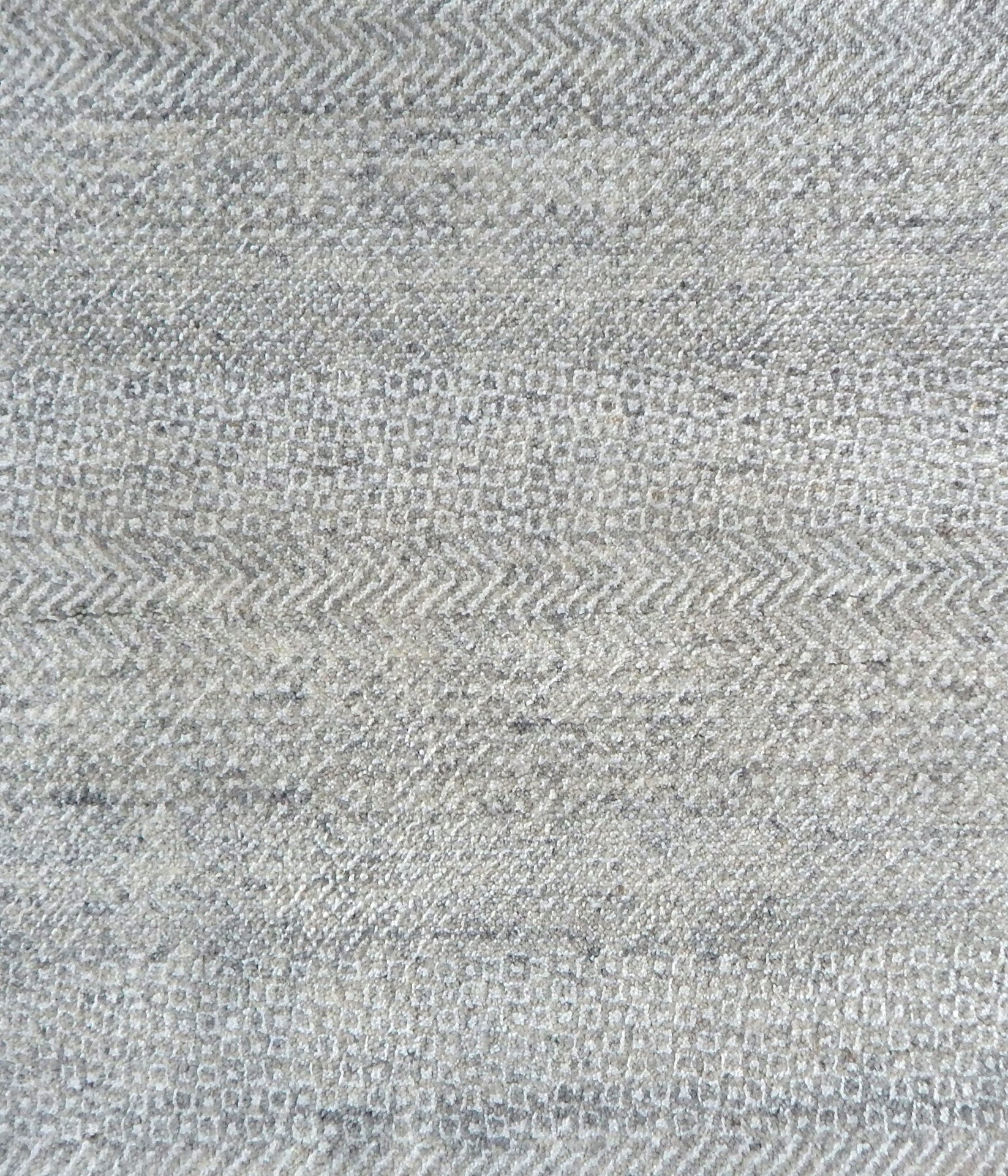 Handknotted rug with small scale geometric pattern in light grey.