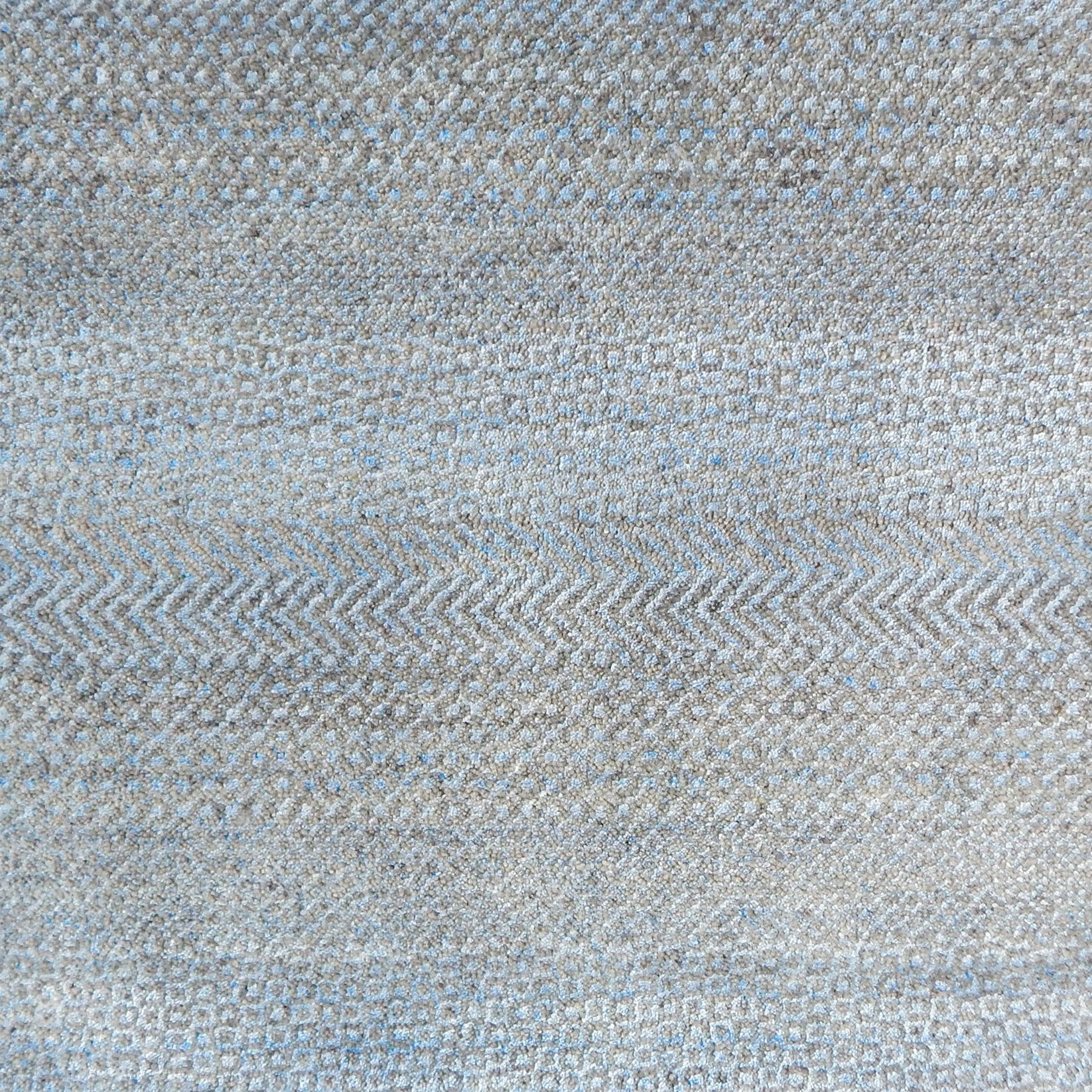 Handknotted rug with small scale geometric pattern in grey and blue. 