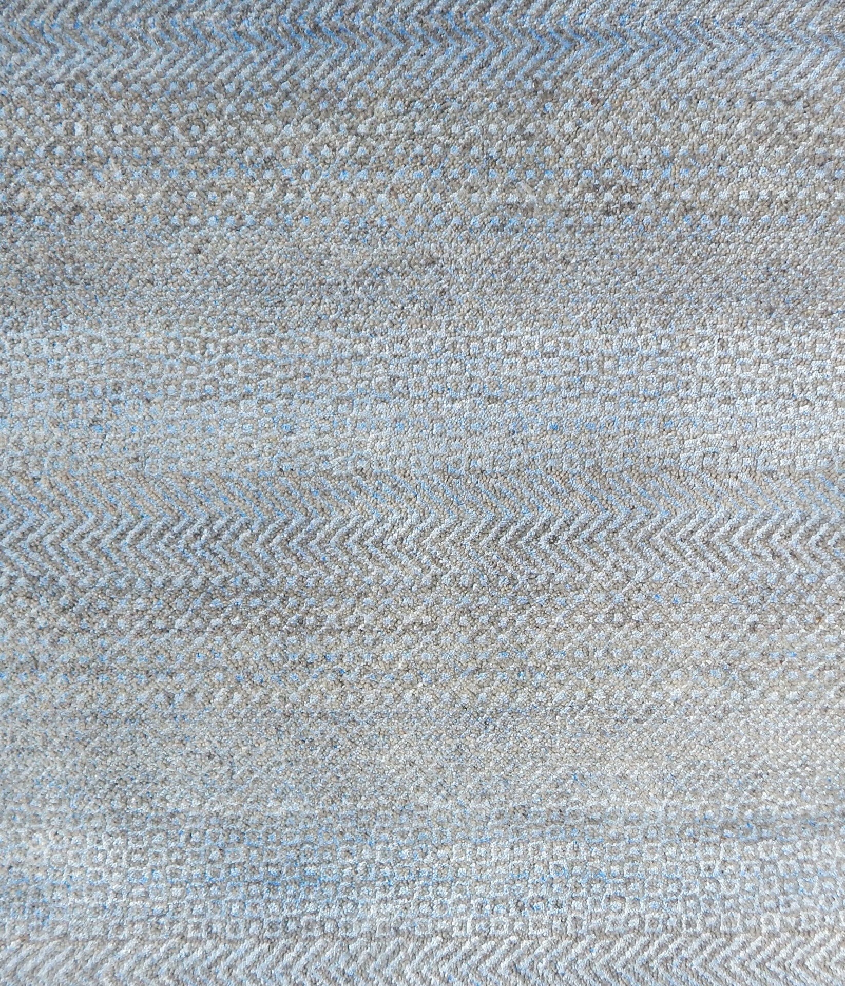 Handknotted rug with small scale geometric pattern in grey and blue. 