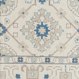 Close-up of an ornate patterned rug with blue and beige colors