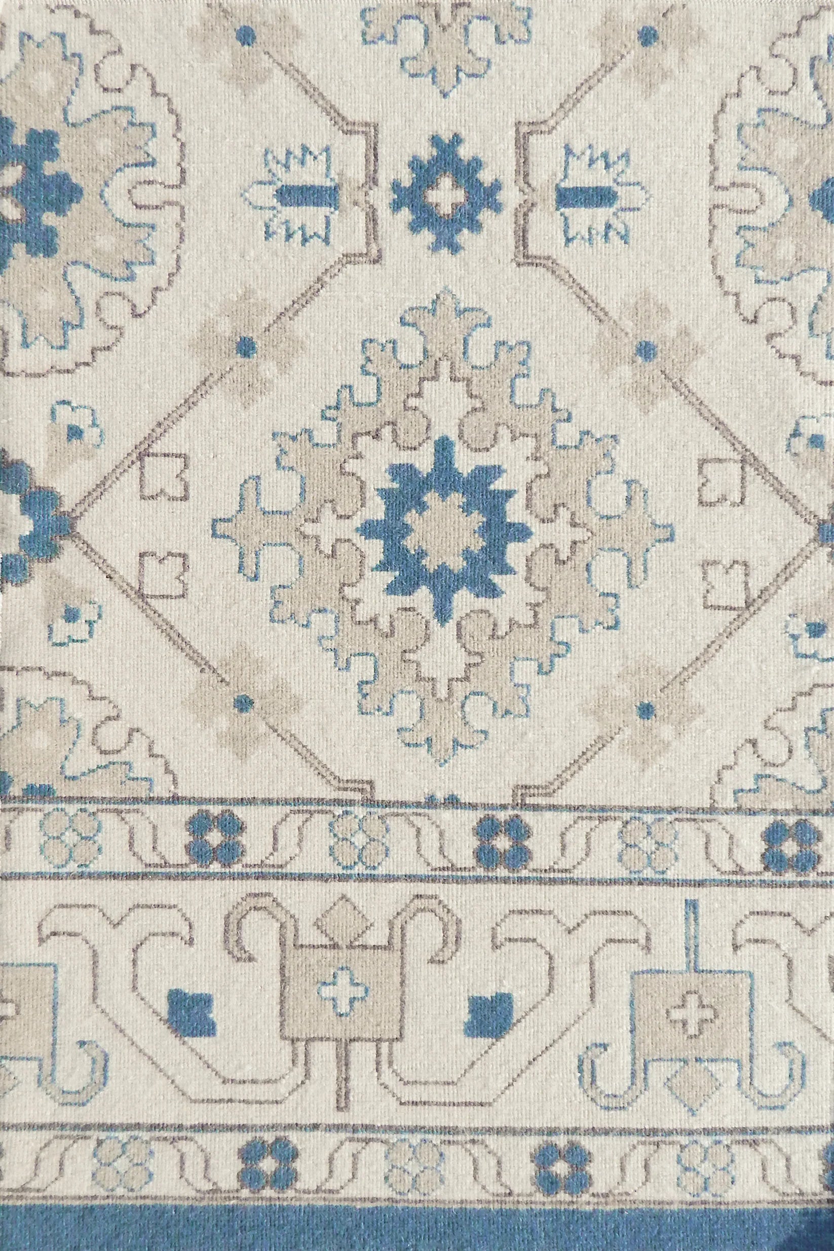 Close-up of an ornate patterned rug with blue and beige colors