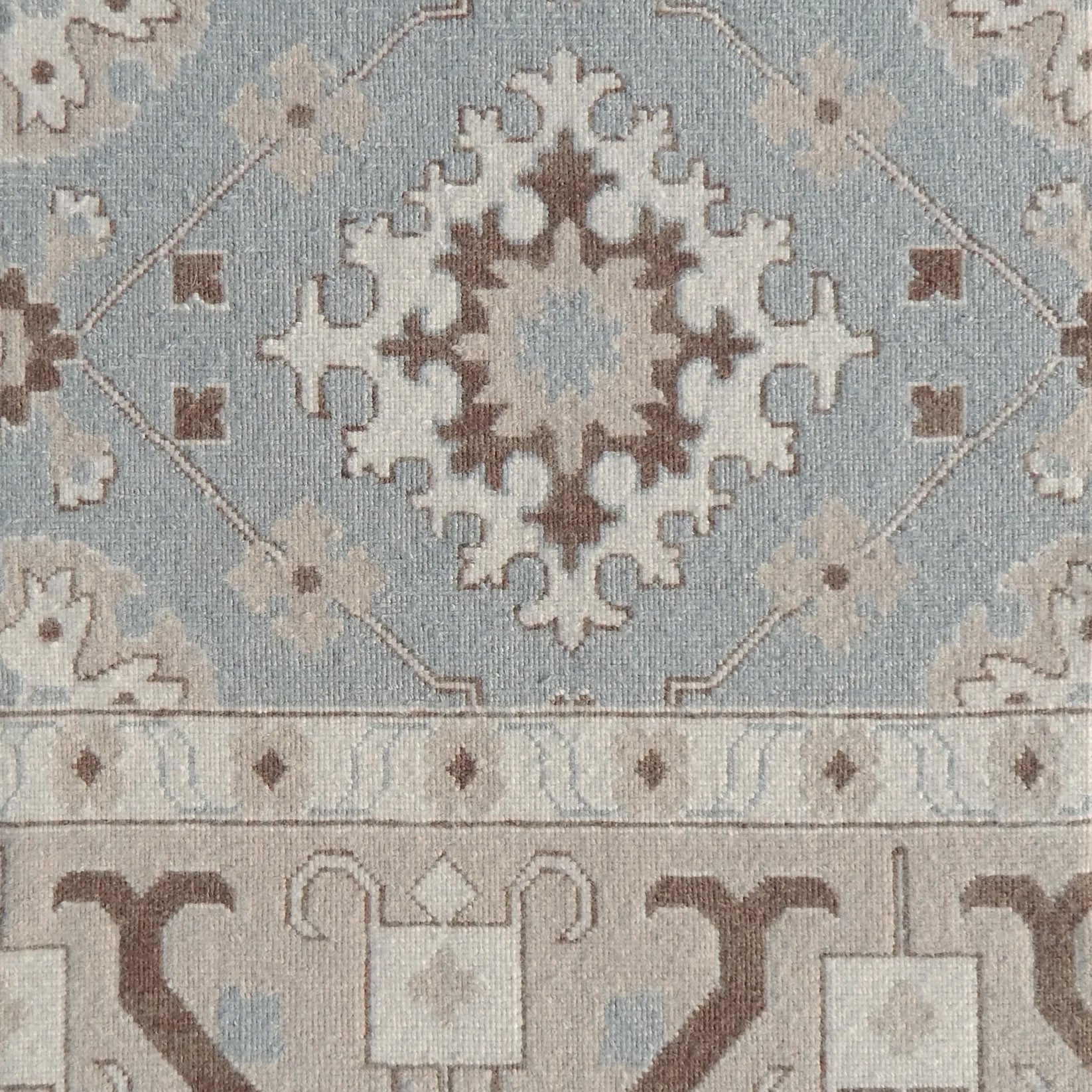 Decorative rug with intricate pattern in blue and brown. 