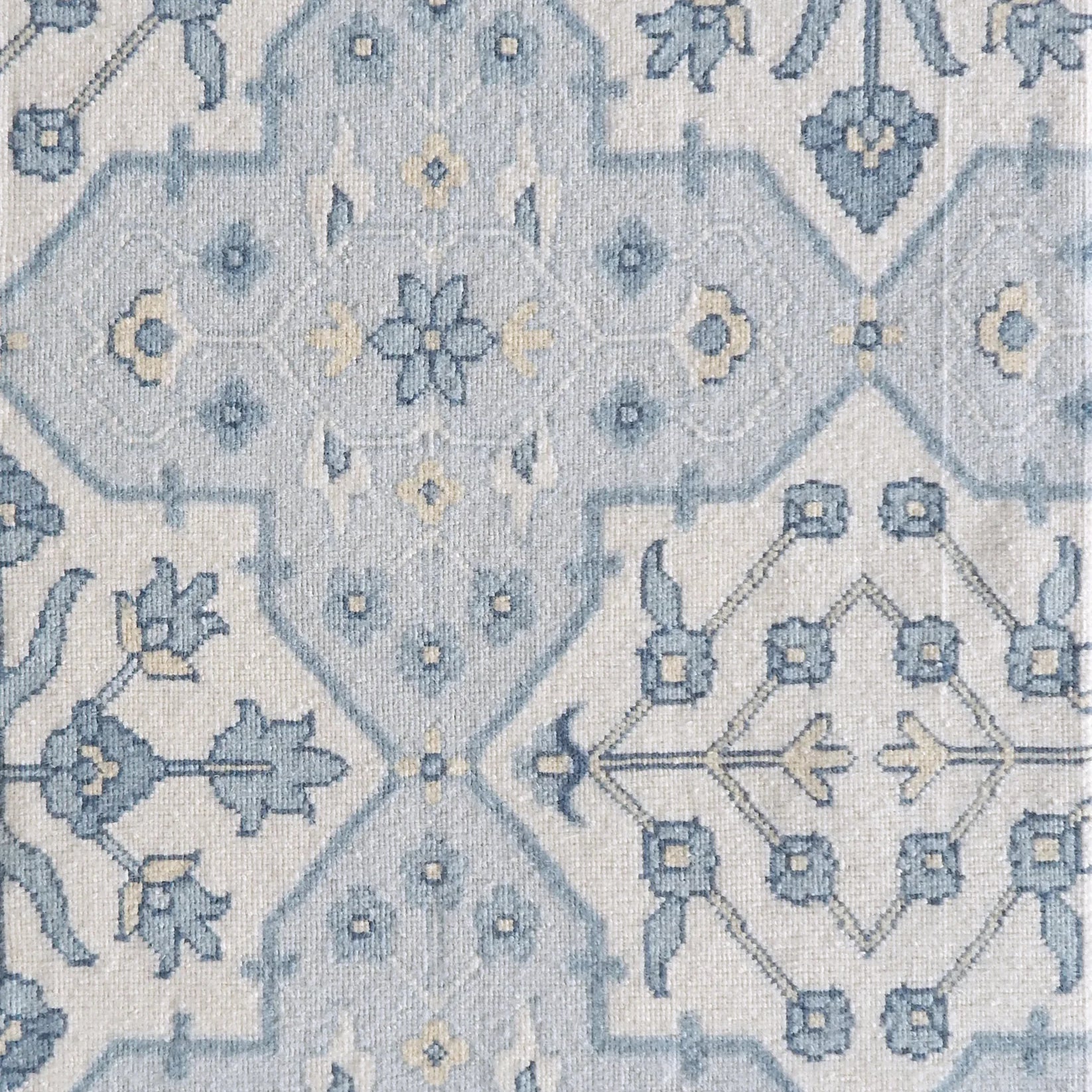 Patterned rug with blue and cream ornate geometric design