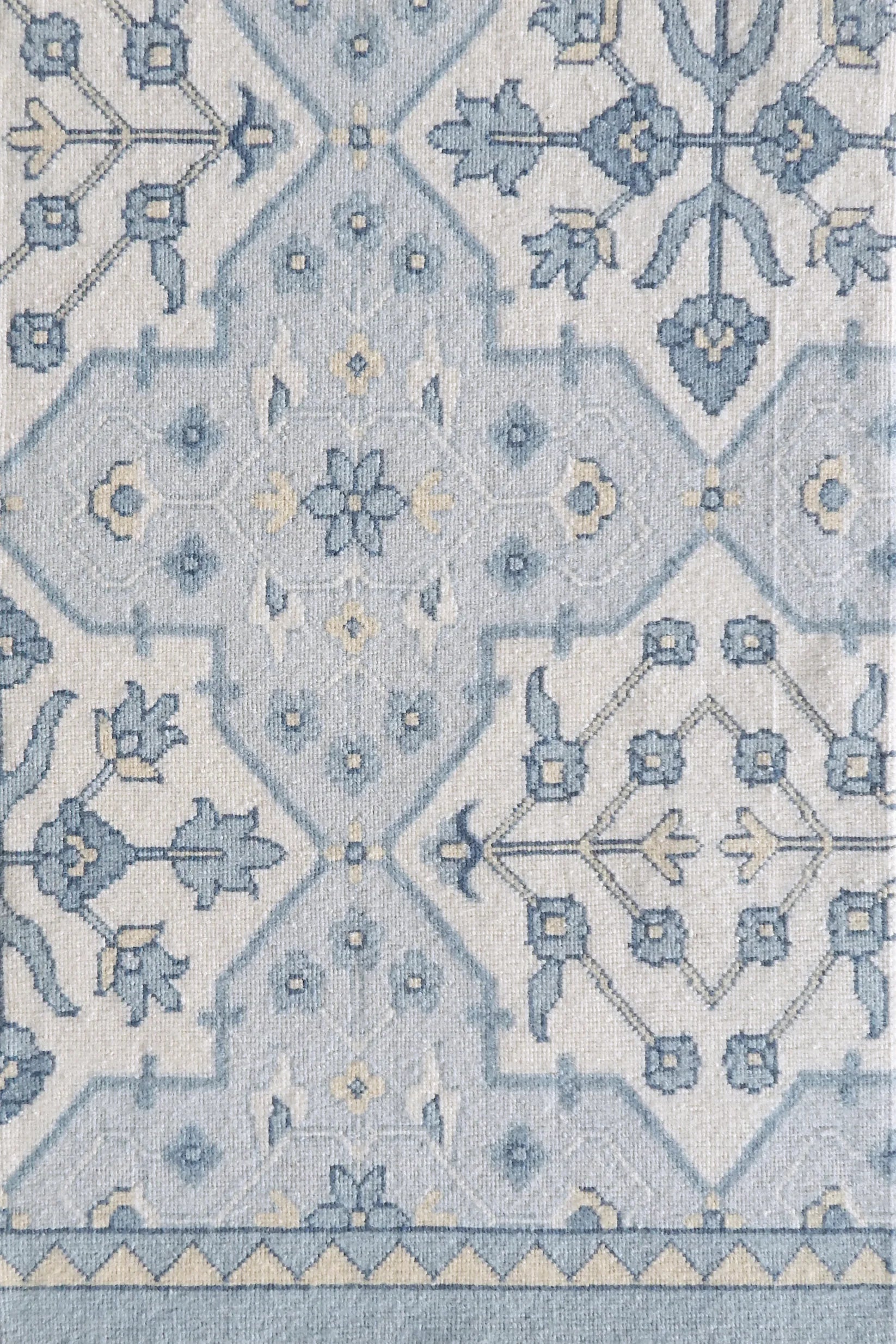 Patterned rug with blue and cream ornate geometric design
