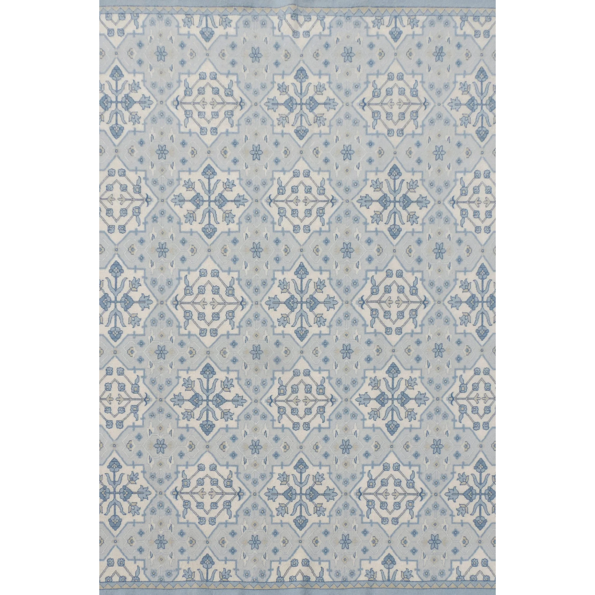 Patterned rug with geometric design in shades of blue on a plain background