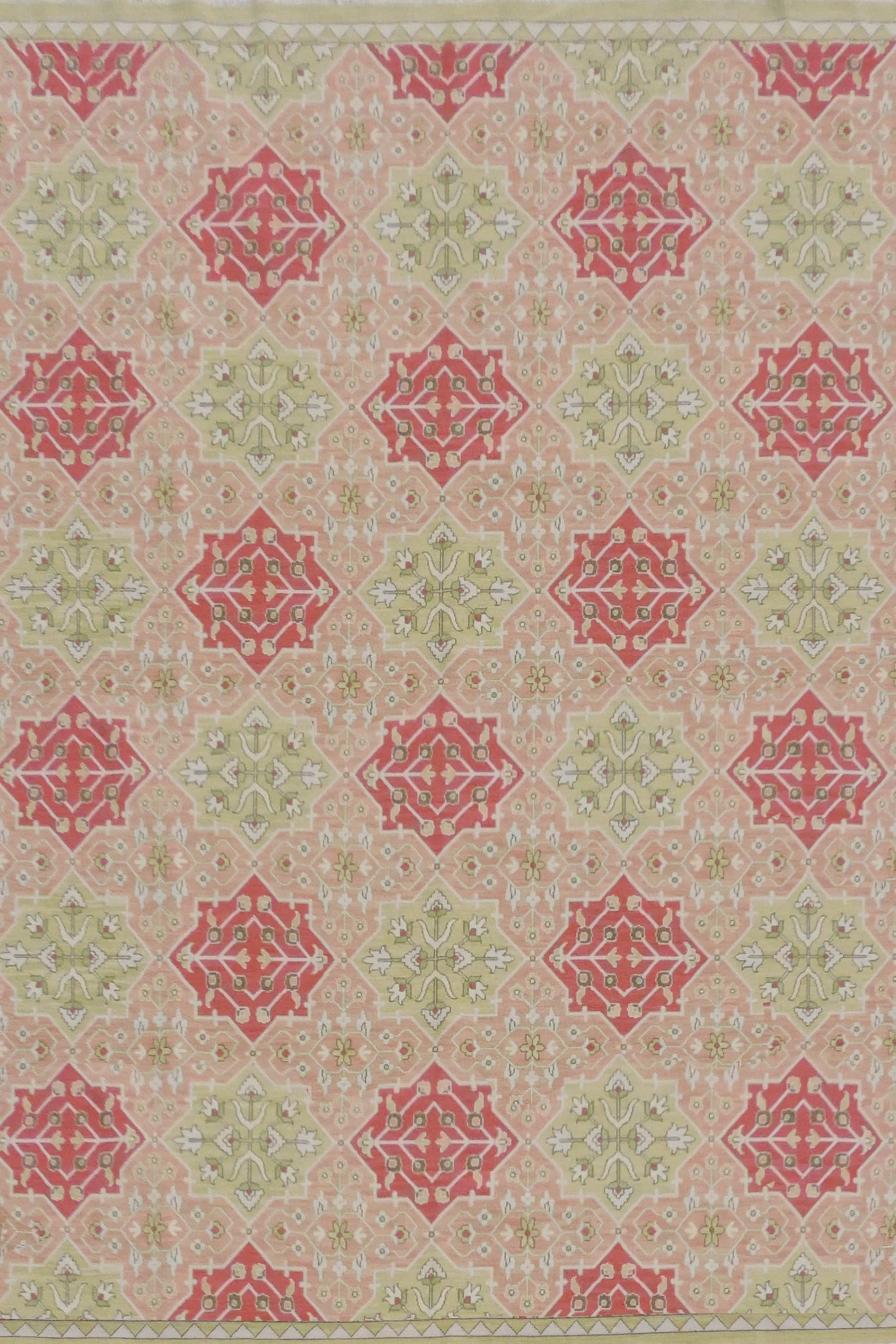 Decorative rug with red and green geometric pattern on a beige background