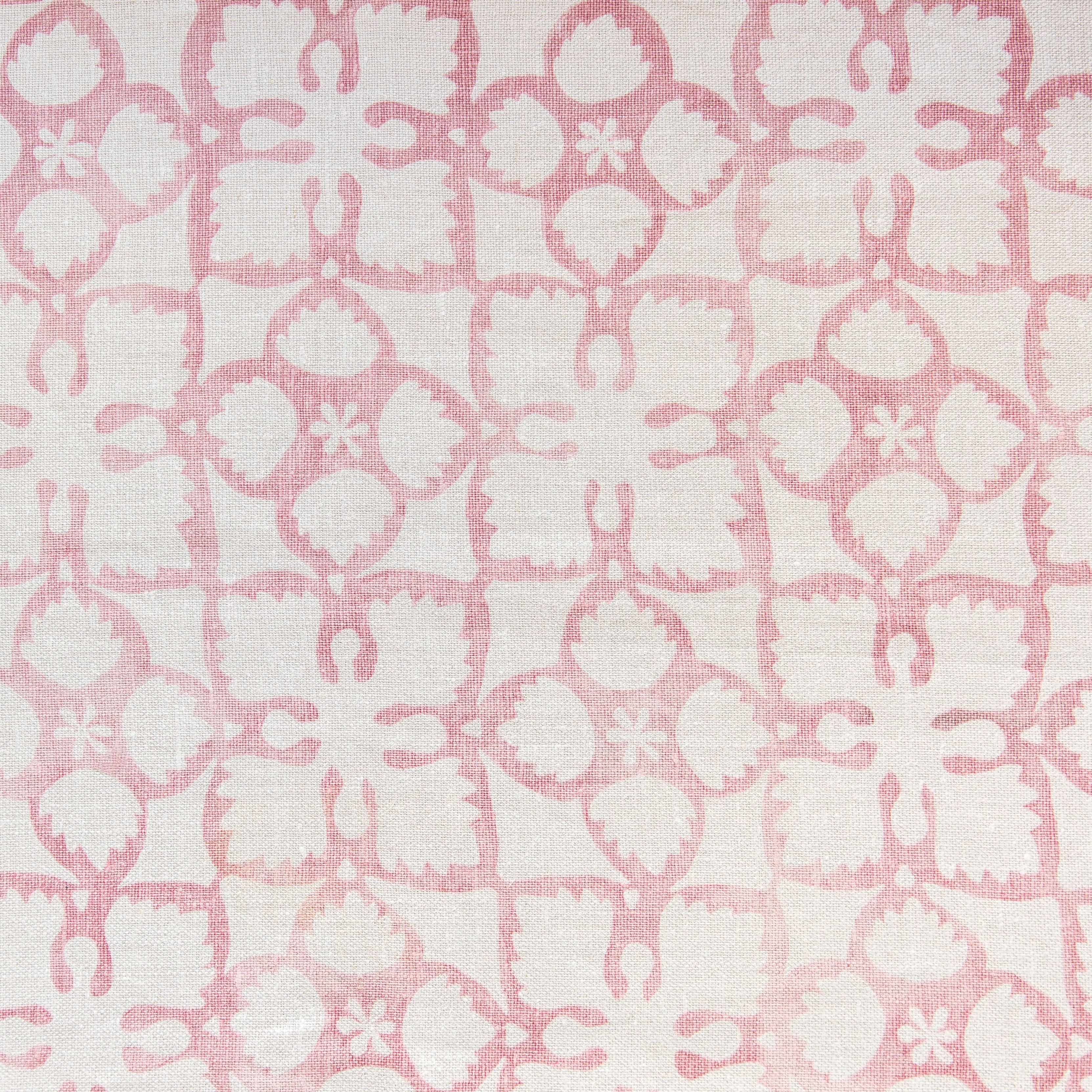 Detail of fabric in a botanical lattice print in pink on a cream field.