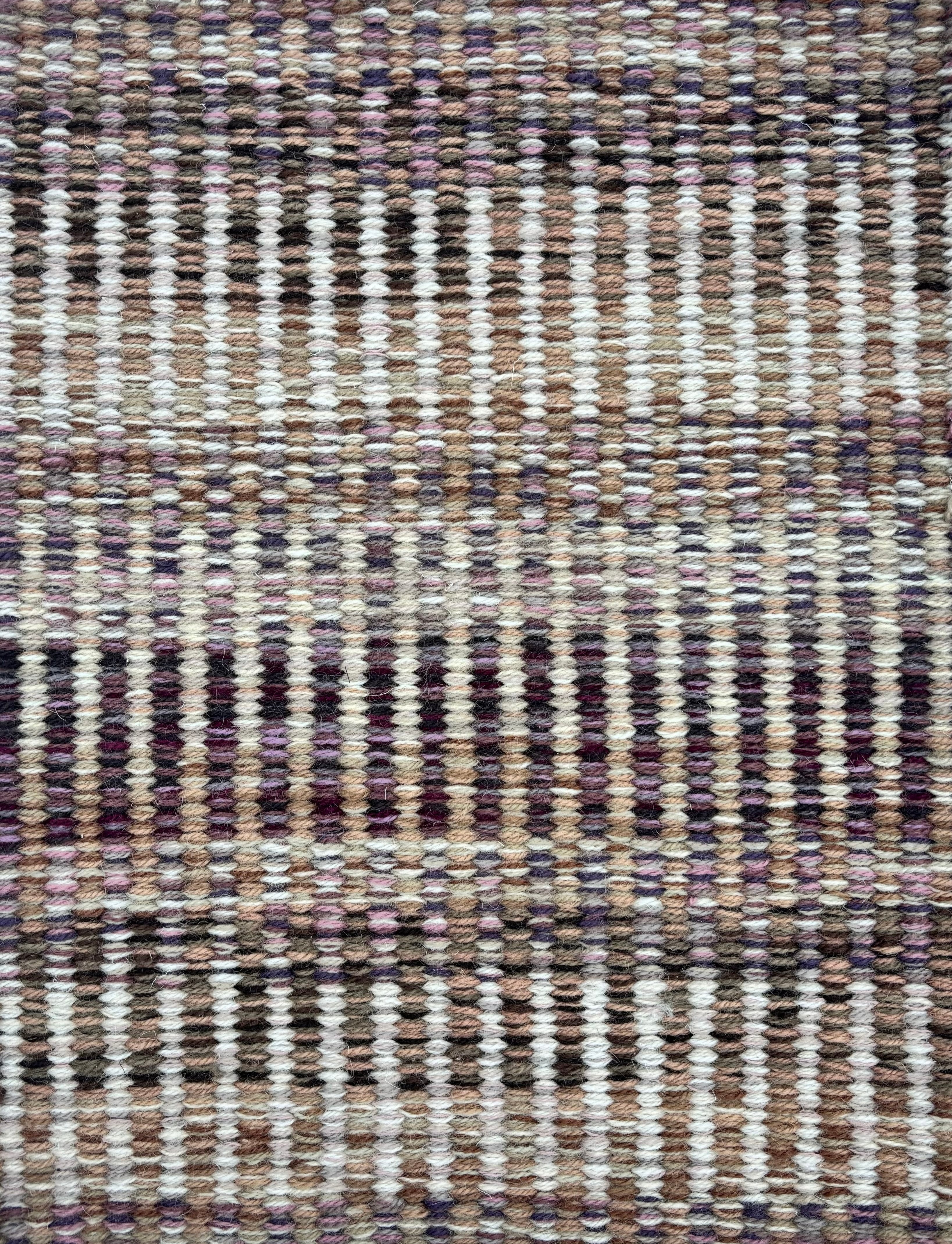 Handwoven rug sample in a textural stripe design in mottled shades of ivory, grey, plum purple and tan. 