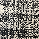 Close-up of mottled black and white upholstery leather yardage in a basket weave.