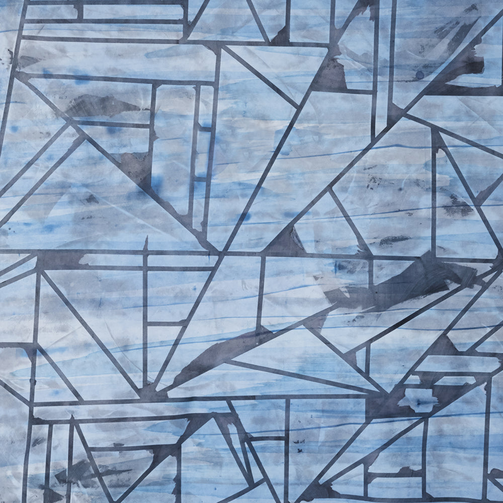 Close-up of a cowhide rug in mottled blue and navy with a geometric black overlay.