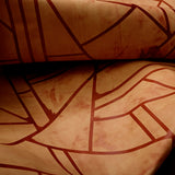 Close-up of a draped cowhide rug in mottled tan with a geometric brown overlay.