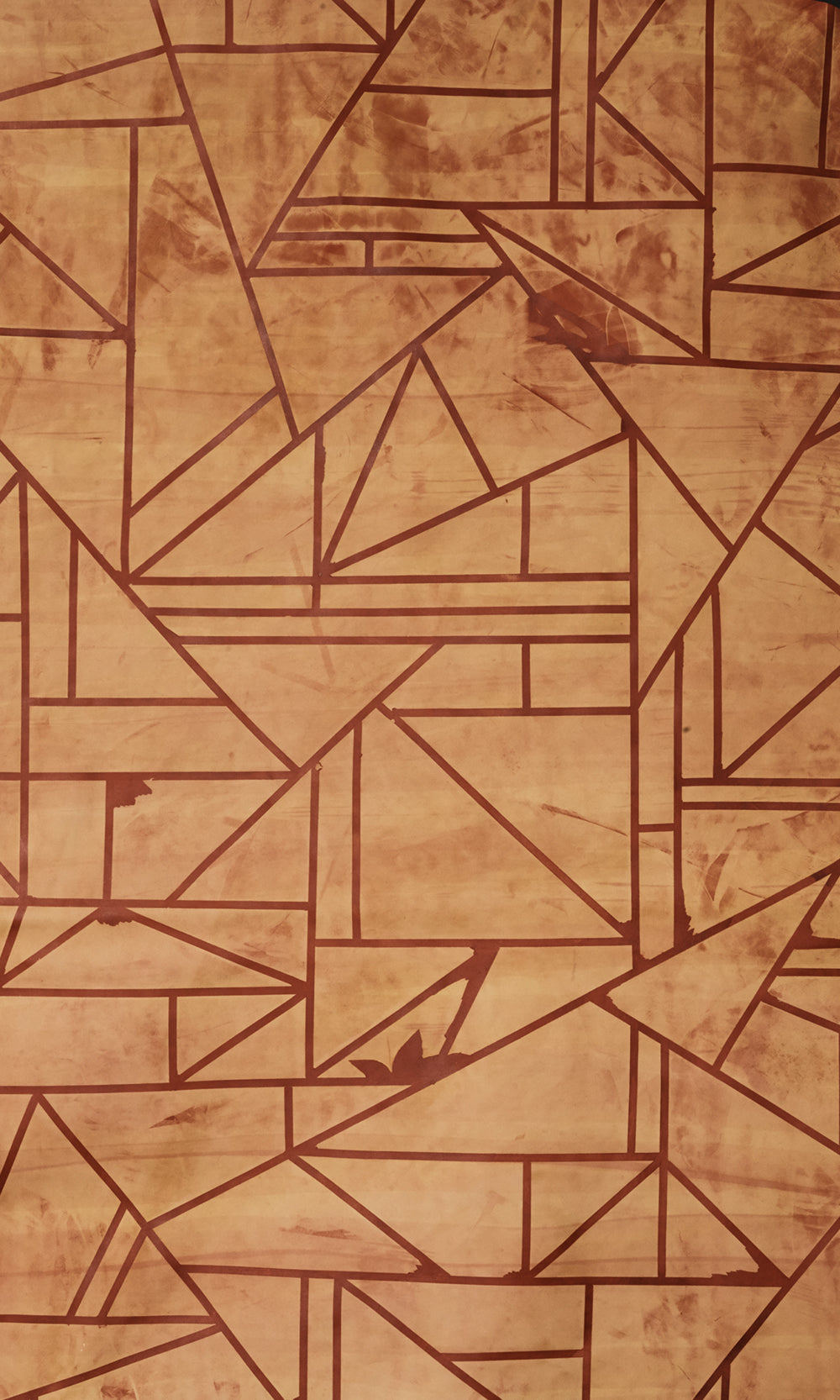 Close-up of a cowhide rug in mottled tan with a geometric brown overlay.