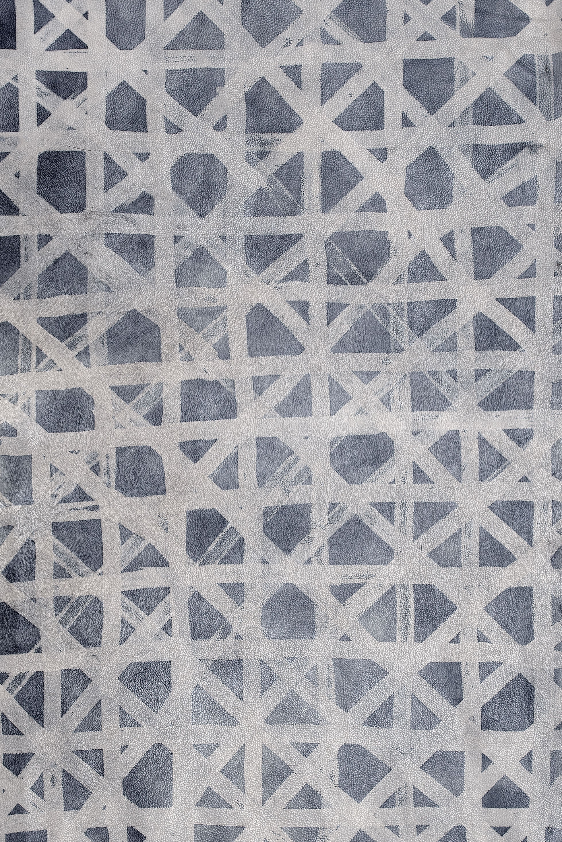 Close-up of cowhide upholstery leather in blue-gray with a white lattice overlay.