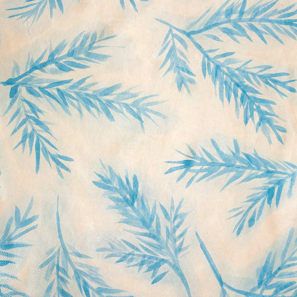 Close-up of cowhide leather in cream with a blue botanical overlay.