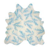 Detail of a cowhide rug in cream with a blue botanical overlay.