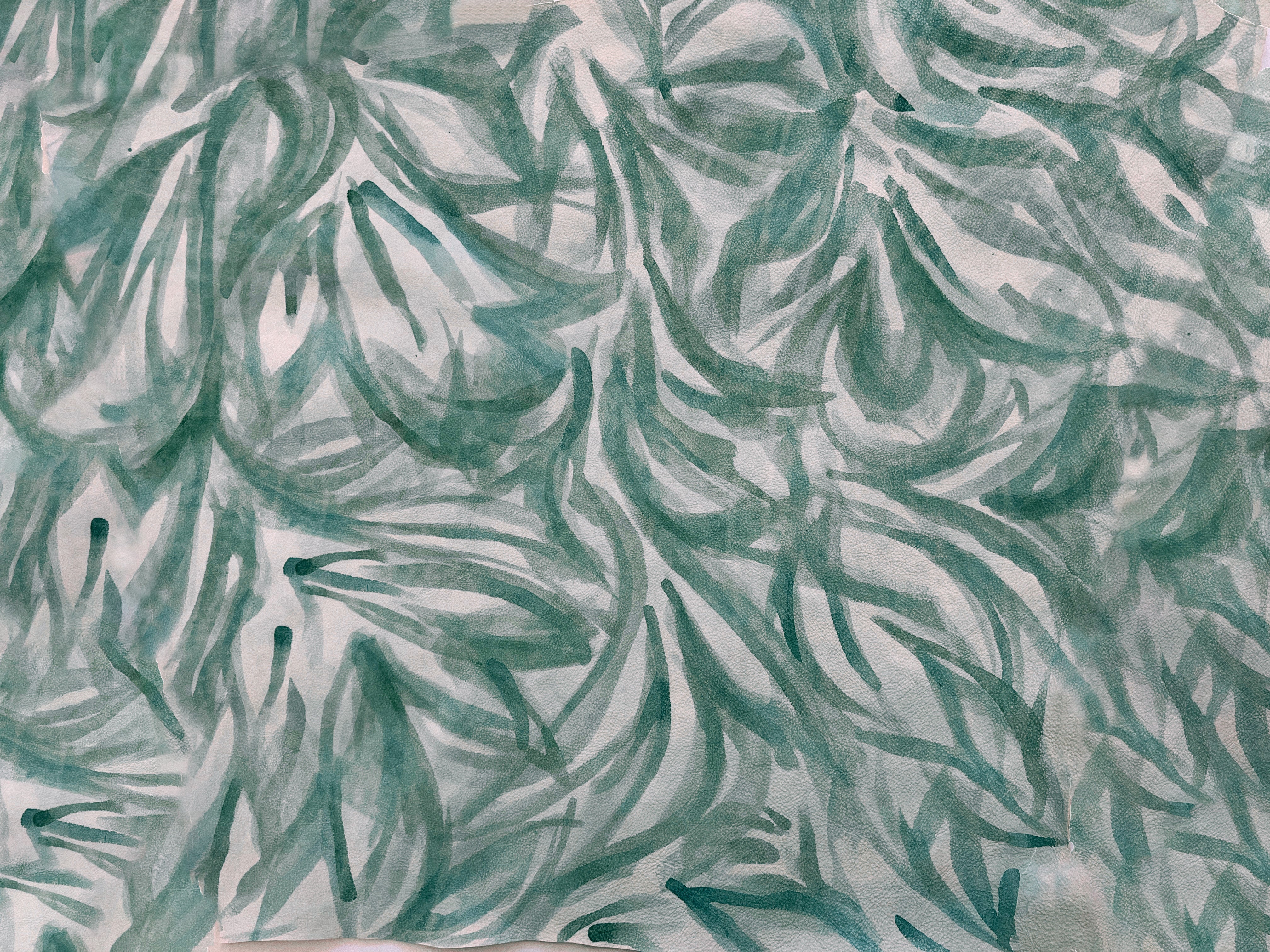 Close-up of a cowhide rug in cream with a painterly botanical overlay in green and gray.