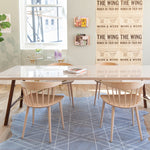 A cozy workspace with a table and chairs sitting on a cowhide rug with a geometric overlay.