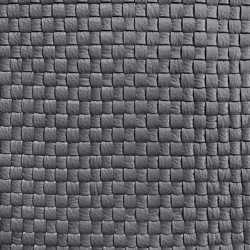 Detail of upholstery leather in a woven grid in black.