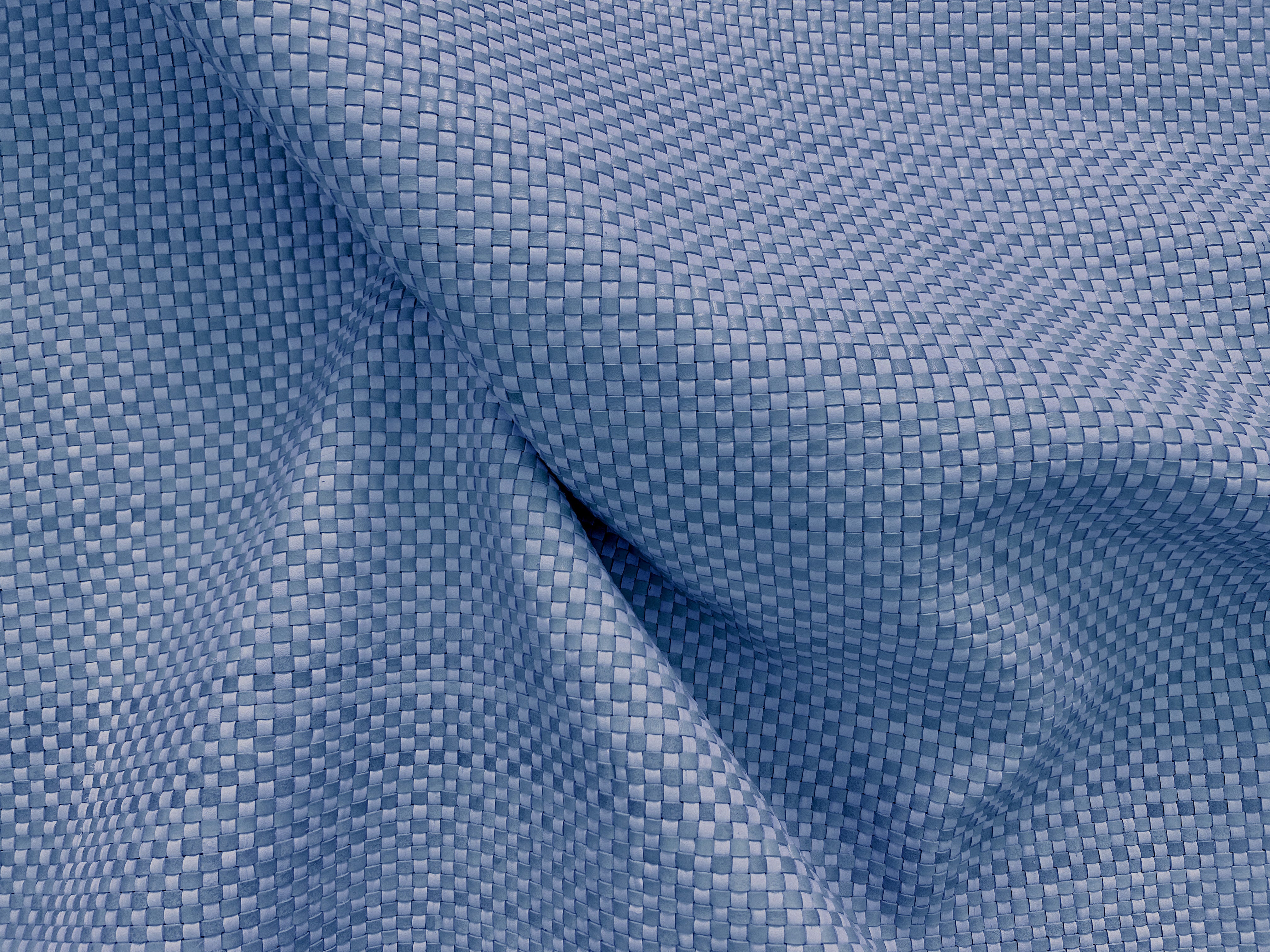 Draoed upholstery leather yardage in a woven grid in blue.
