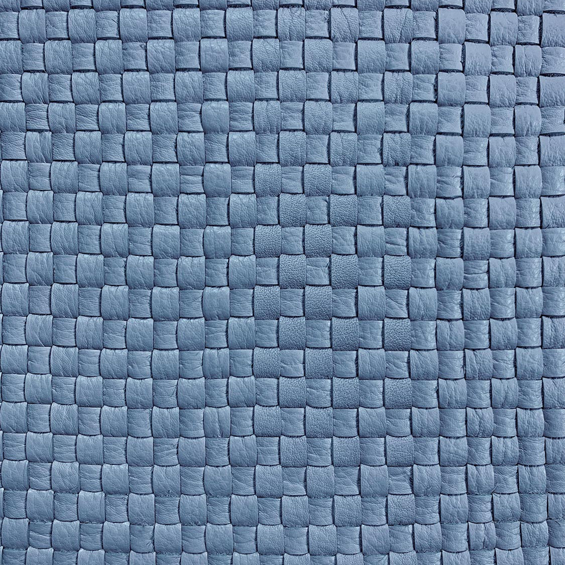 Detail of upholstery leather in a woven grid in blue.