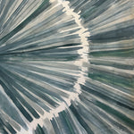 Close-up of a cowhide rug in cream with an abstract painterly overlay in shades of green and gray.