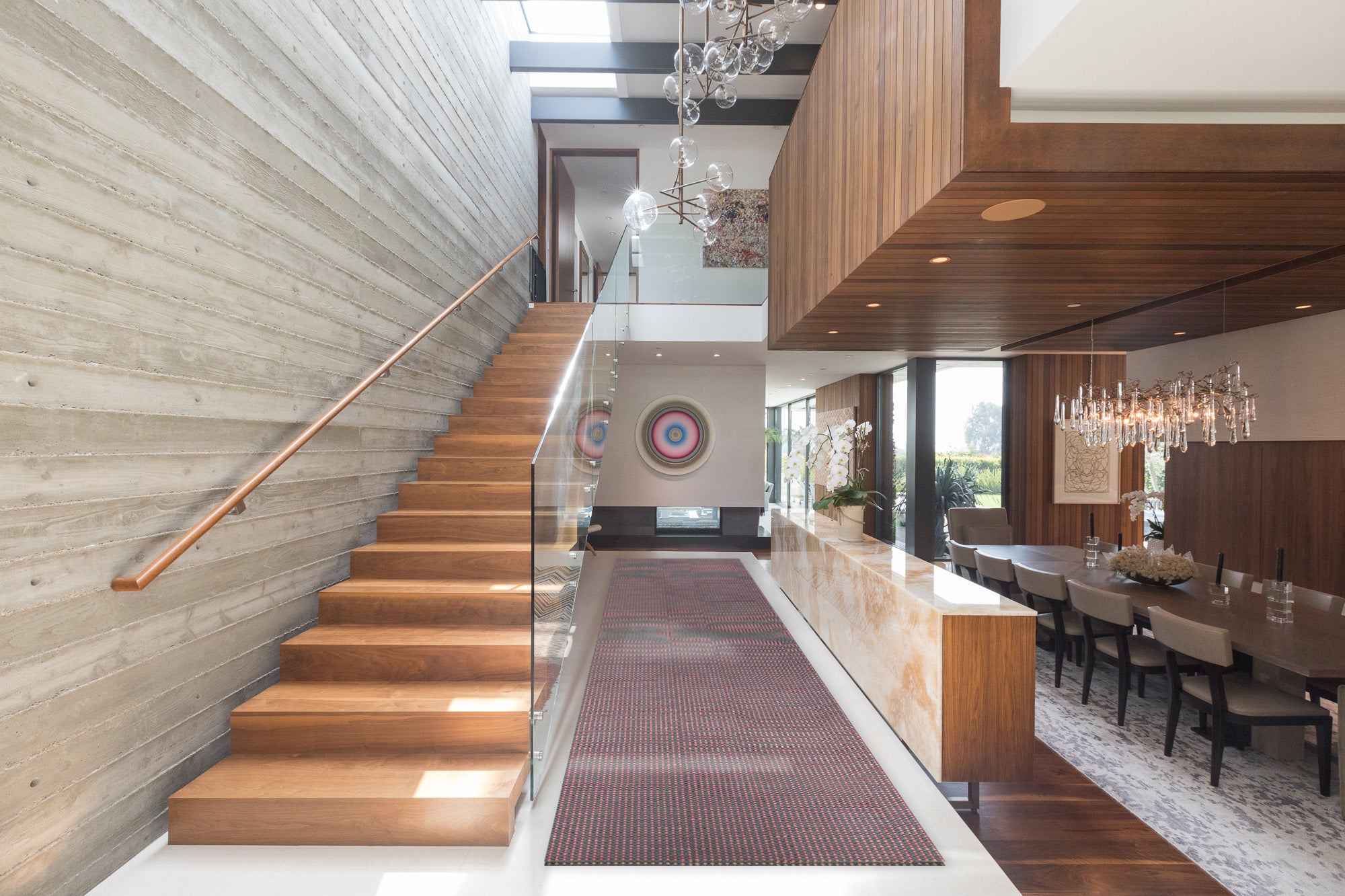 An airy open-plan living space with a dining room, stairwell and floating second-story room.