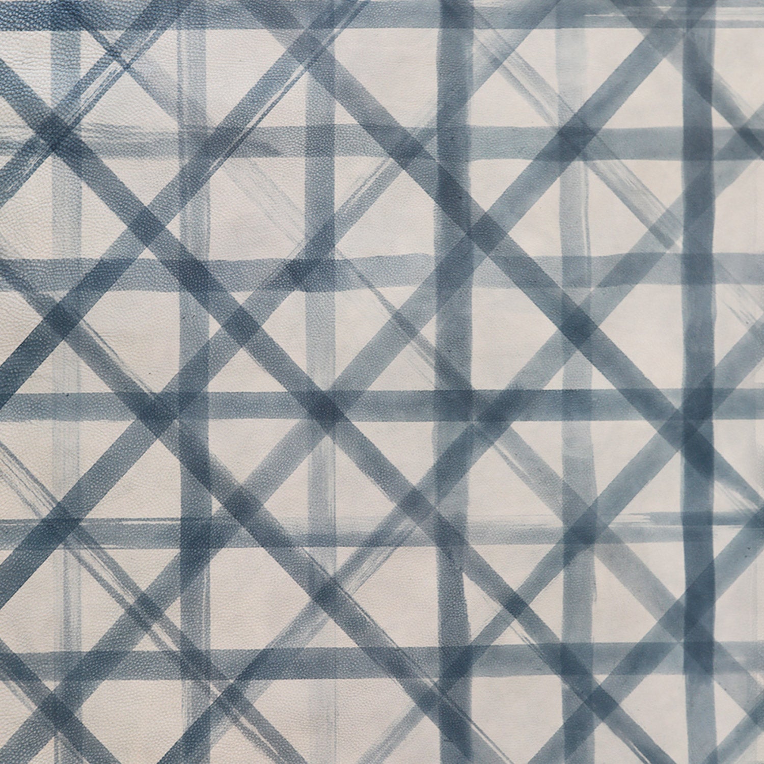 Close-up of cowhide upholstery leather in cream with a blue-gray lattice overlay.