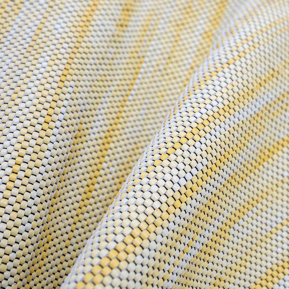 Close-up of draped upholstery leather in a tight woven texture in yellow and white.