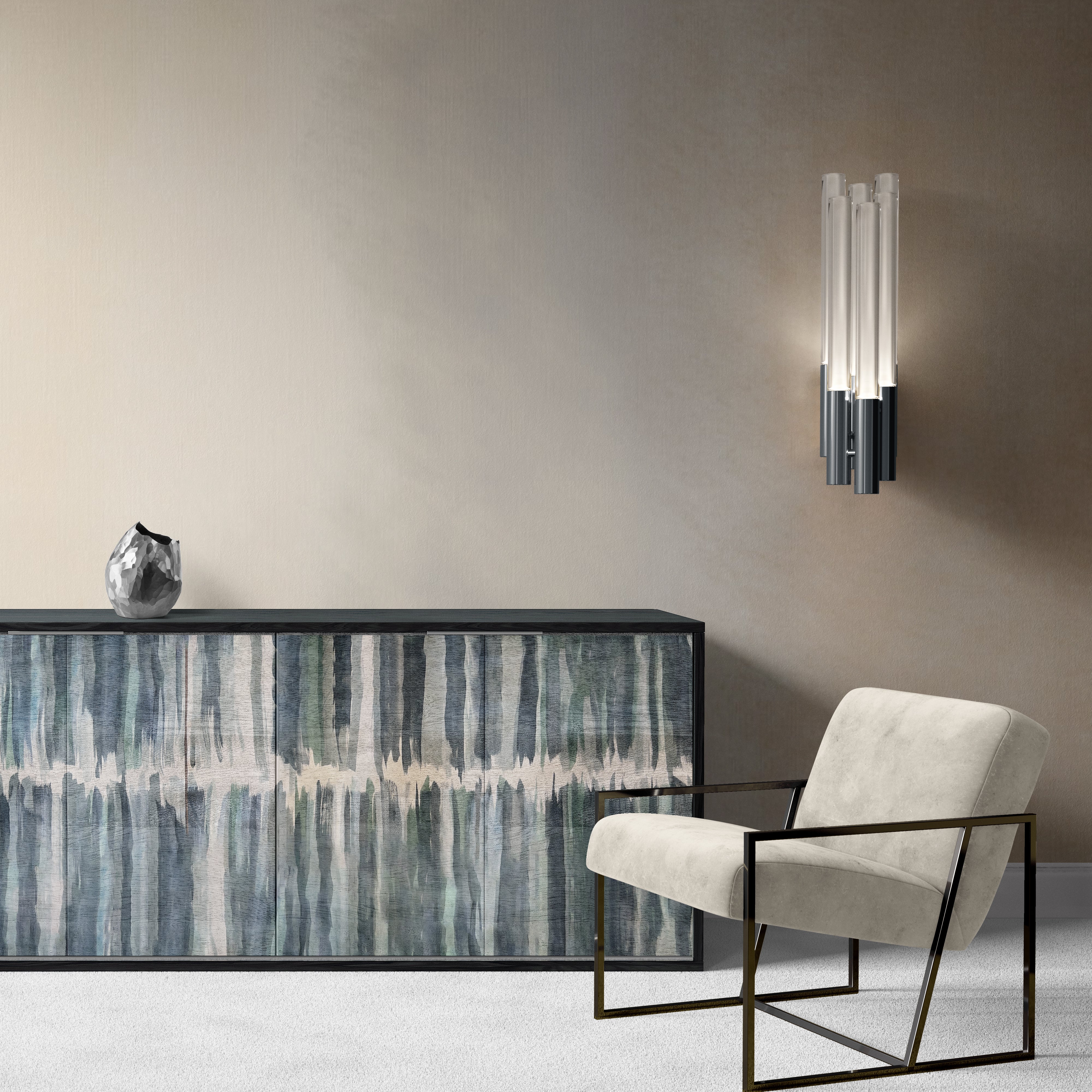 A modernist living room tableau with a sideboard upholstered in leather in a painterly stripe print in cream, green and gray.