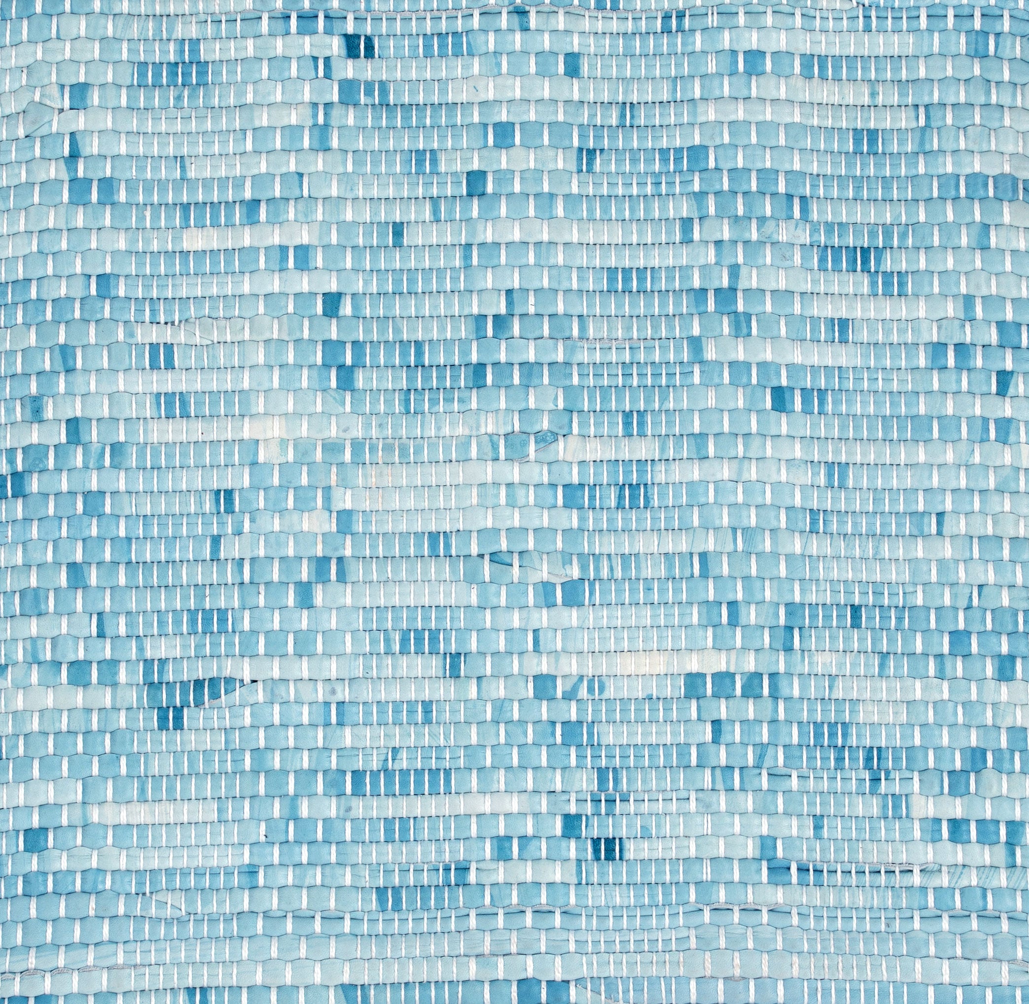 Close-up of a woven leather rug in a mottled blue colorway.