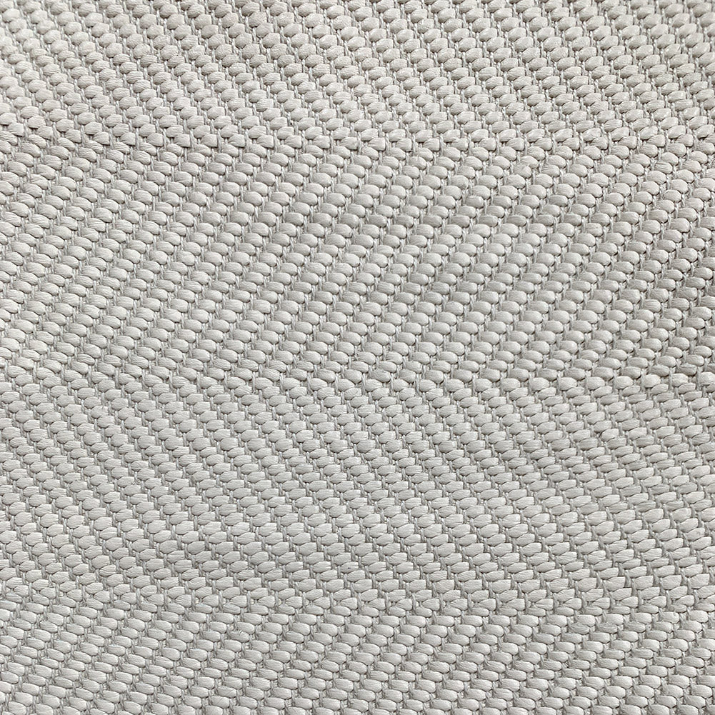 Detail of woven upholstery leather in a herringbone pattern in light gray.