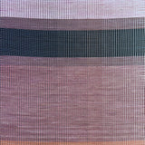 Overhead shot of a leather rug in a woven stripe pattern in shades of purple, black, coral and yellow.