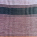 Overhead shot of a leather rug in a woven stripe pattern in shades of purple, black, coral and yellow.