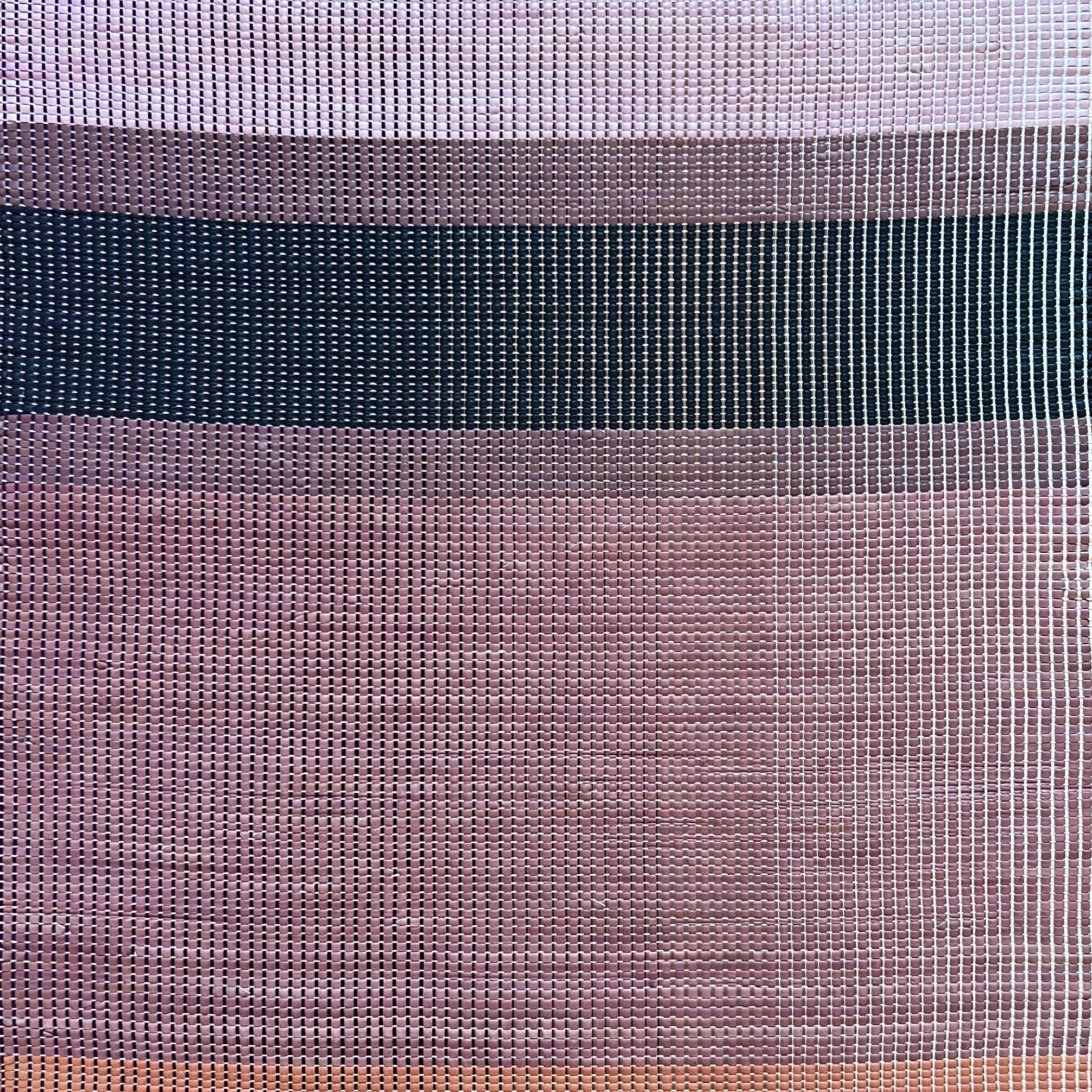 Overhead shot of a leather rug in a woven stripe pattern in shades of purple, black, coral and yellow.
