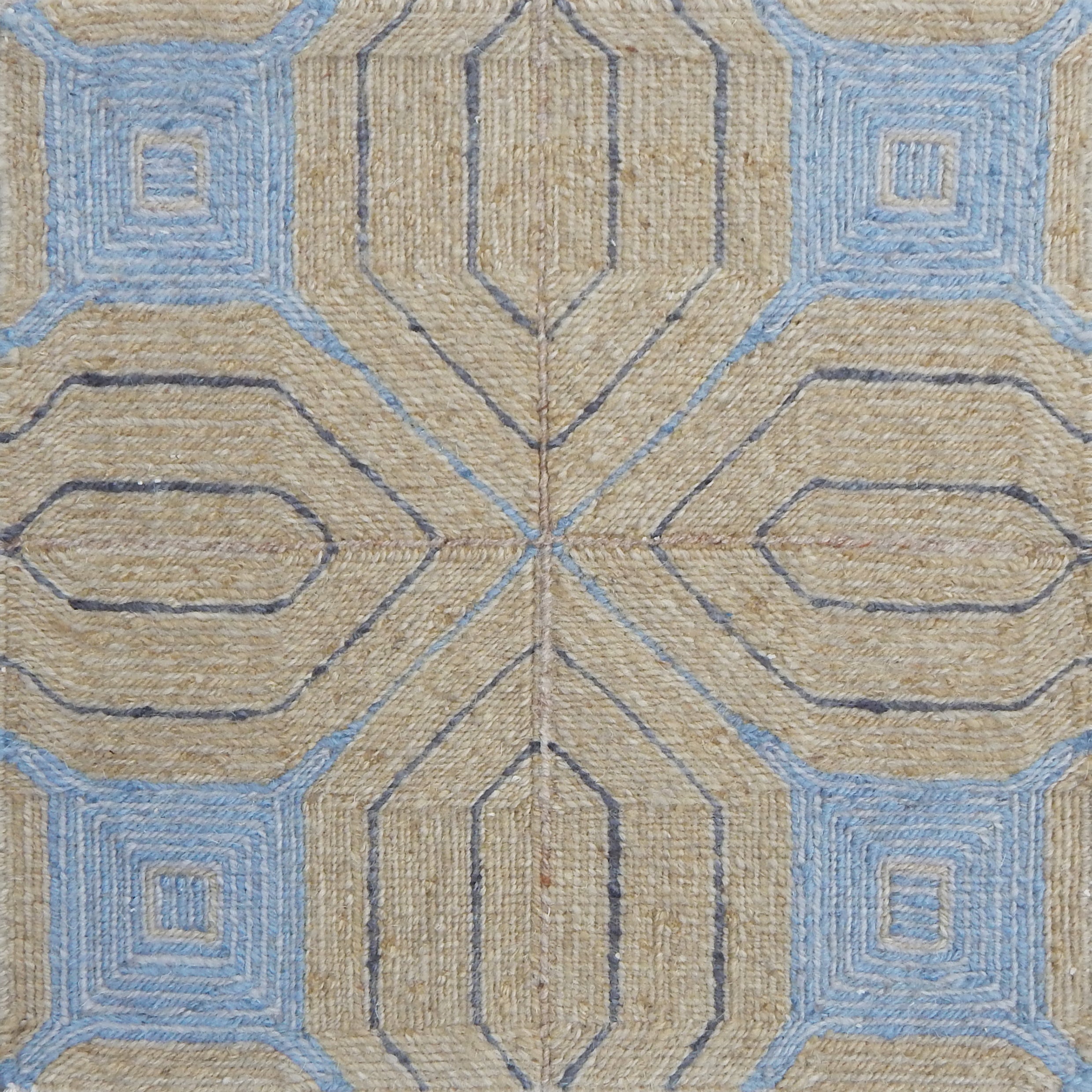 Close-up of a textured rug with geometric pattern in beige and blue