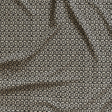 Close up of gently draped fabric with small scale geometric lattice design in beige on black. 