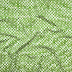 Close up of gently draped fabric with small scale geometric lattice design in white on green.