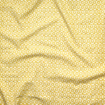Close up of gently draped fabric with small scale geometric lattice design in white on yellow. 