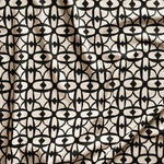 Close up of gently draped fabric with large scale geometric lattice design in black on white.