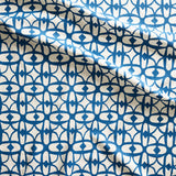 Close up of gently draped fabric with large scale geometric lattice design in white and blue.